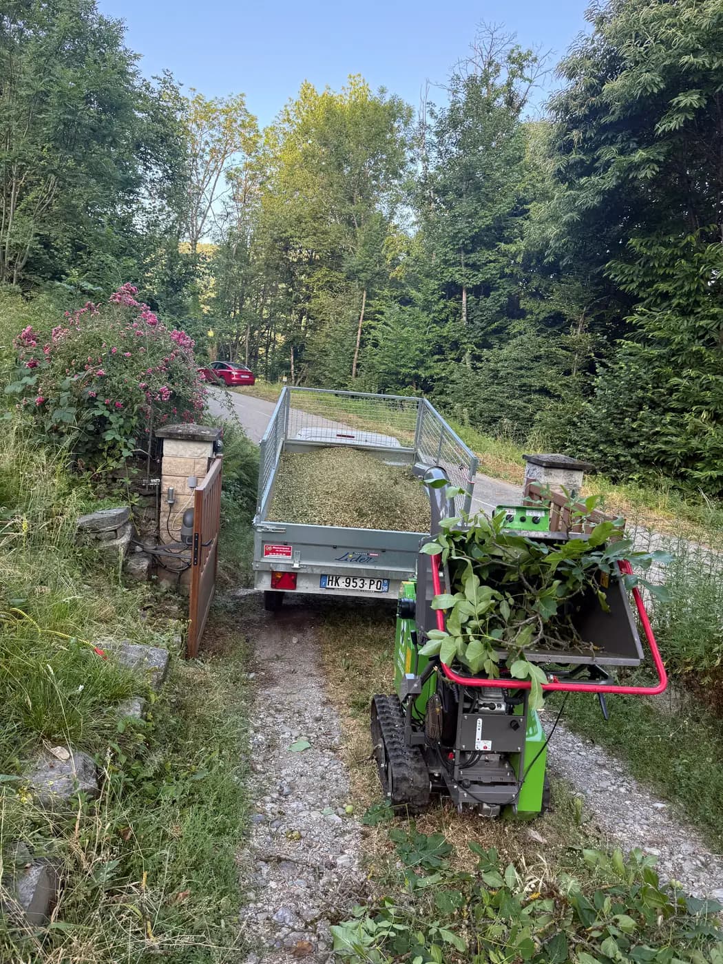 Broyeur de branches chenillé et remorque sur un chantier